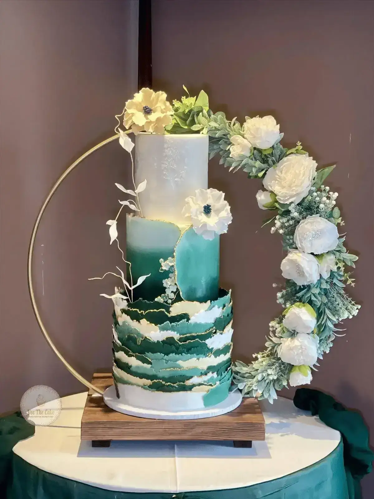 Statement teal and white wedding cake with floral hoop