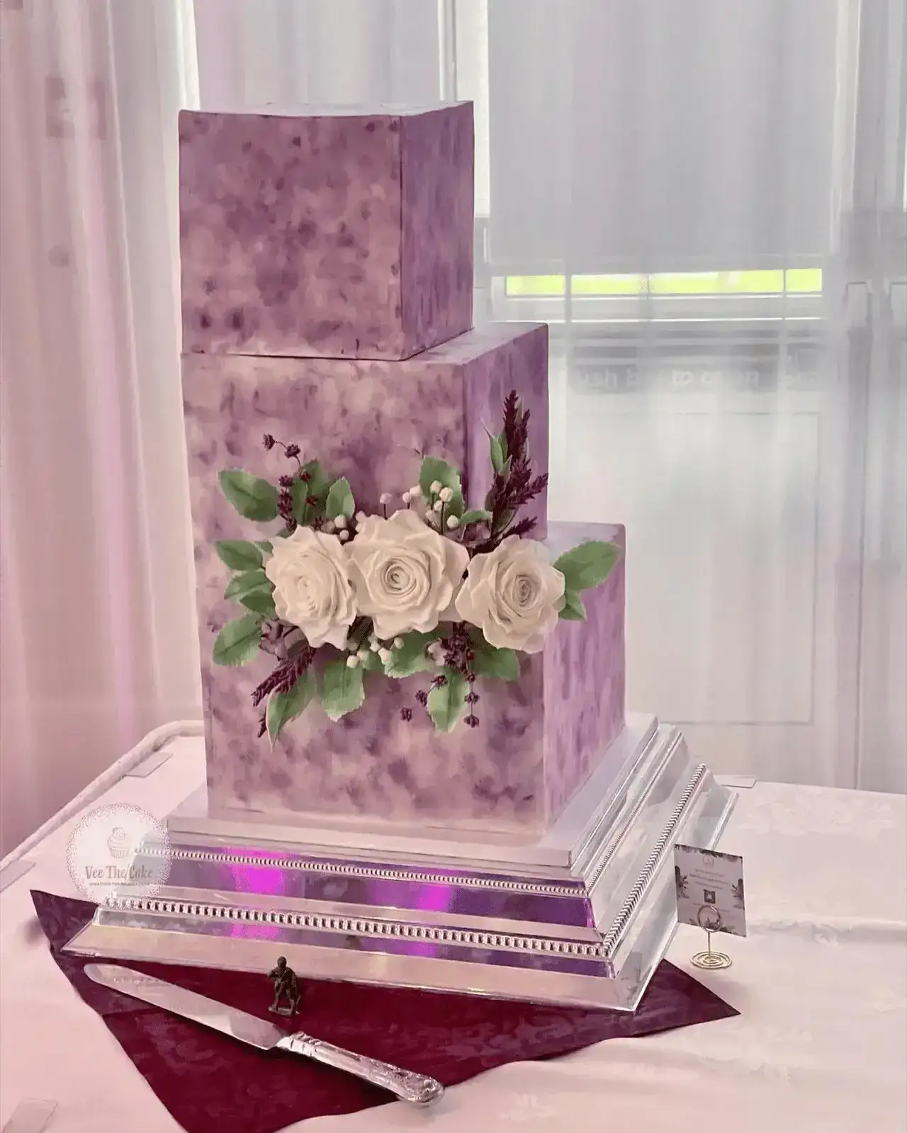 Geometric purple wedding cake with sugar roses