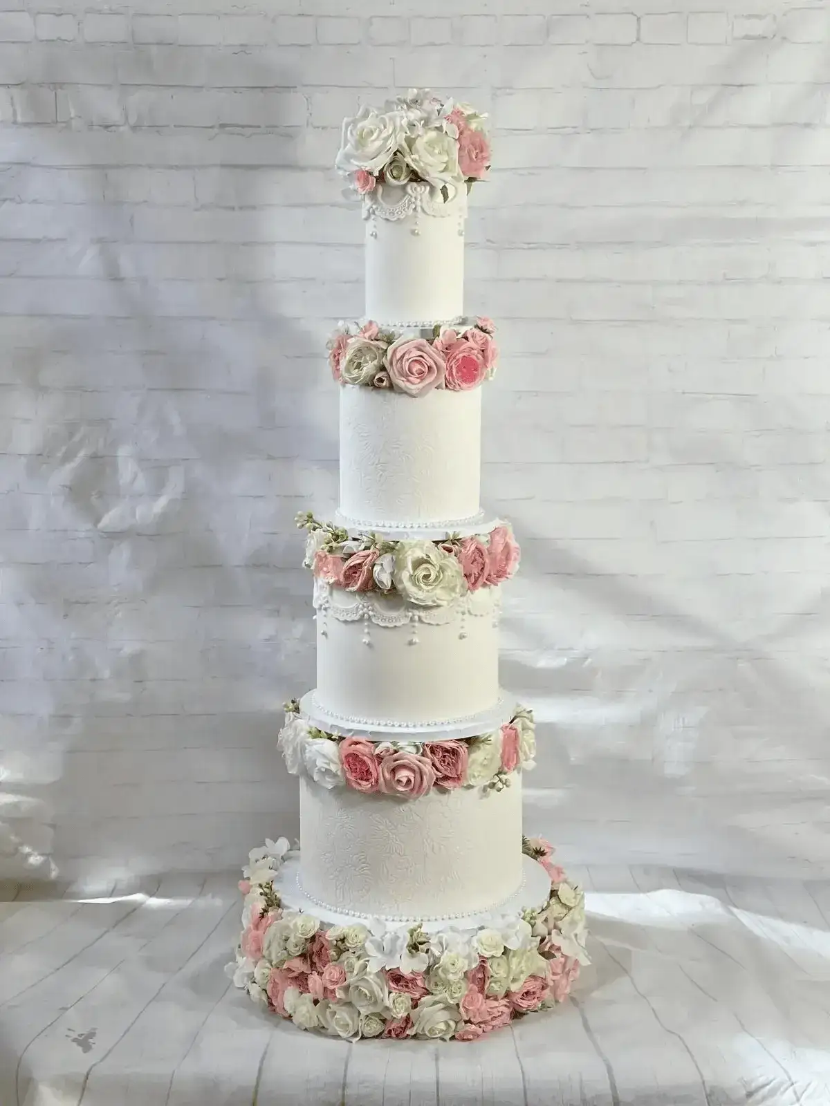 Five-tier white and pink floral wedding cake