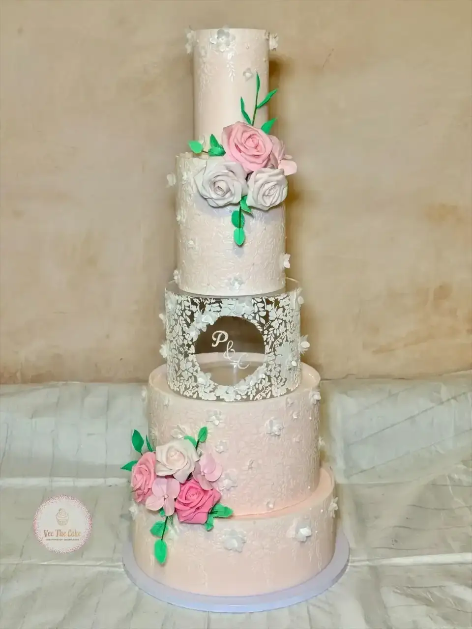 Blush wedding cake with delicate lace and sugar flowers