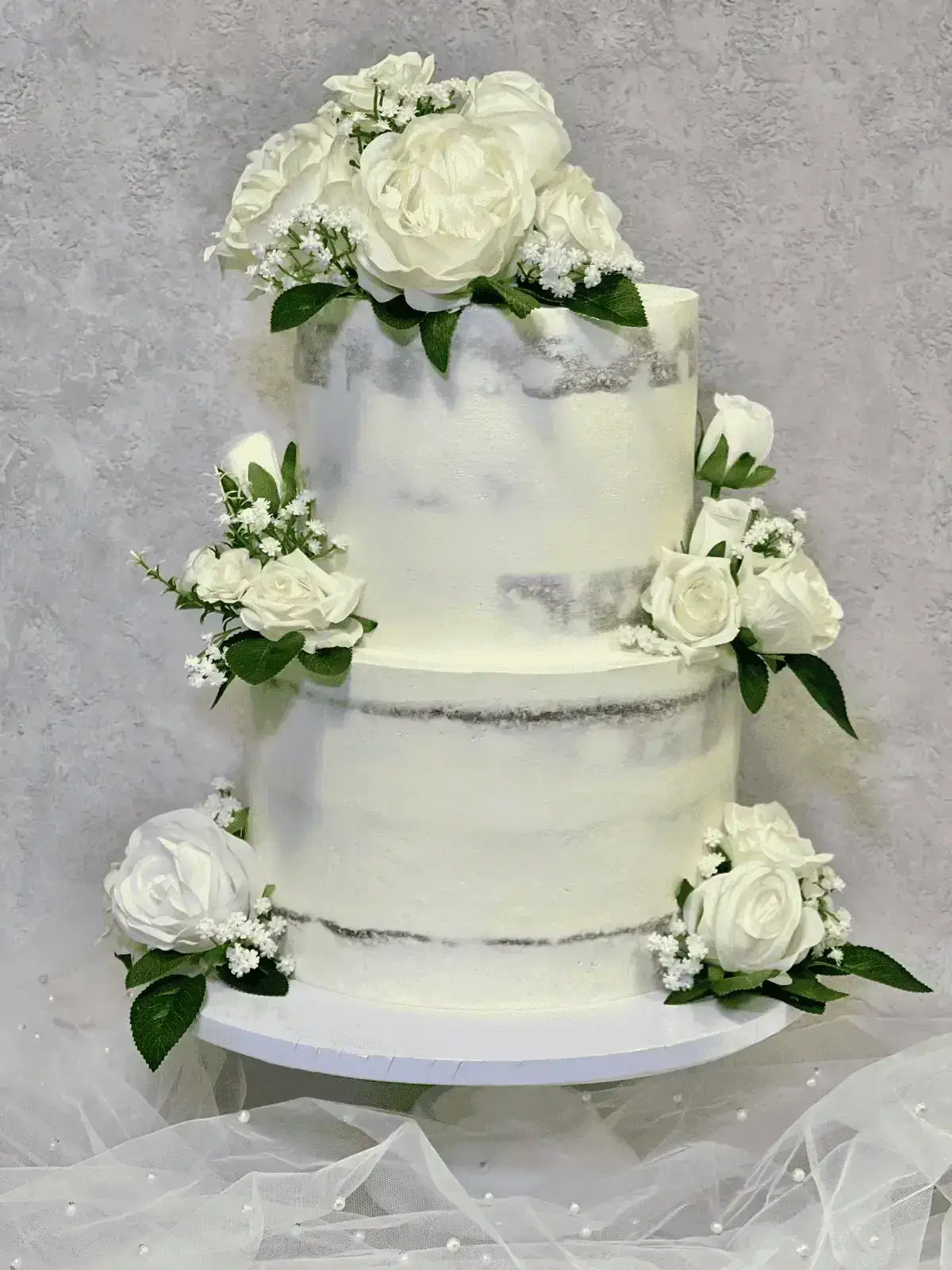 Semi-naked two-tier wedding cake with white roses